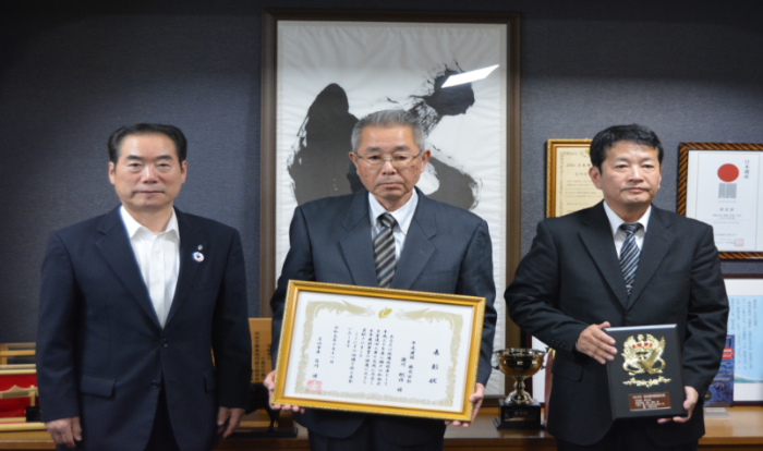 優秀現場技術者を受賞した関係者2名が表彰状と盾を持ち、市長と並んで記念撮影をしている写真