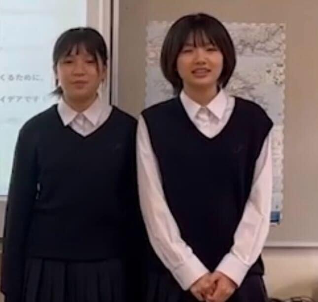 制服を着た2名の女子高生が並んで立っている写真
