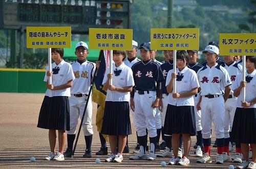 チーム名の書かれたプラカードを先頭に並んでいる選手の写真